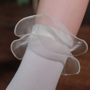 Détail de chaussettes blanches style Lolita avec volants en organza et maille douce