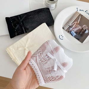 Detailed close-up of lace mesh socks with delicate frills and sweet bow accents