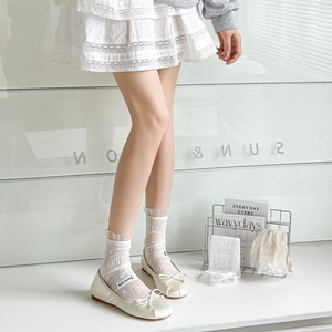 Close-up of white floral lace crew socks paired with chic bow ballet flat shoes
