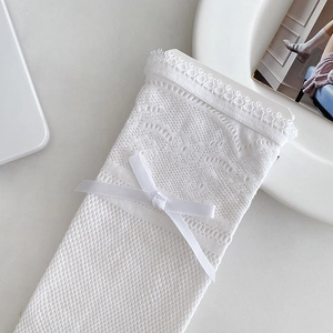 Detail of white Lolita lace socks with floral mesh texture and silk ribbon bow accent