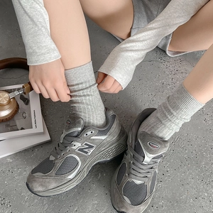 Nahaufnahme der grauen Retro-Sneaker aus Mesh und Wildleder mit grauen Stricksocken