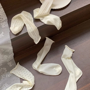 Close-up of white heart hollow mesh lace socks with elegant wavy ruffled edges