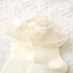 Gros plan détaillé sur des chaussettes Lolita blanc crème avec dentelle en organza
