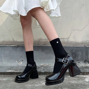 Close-up of black patent leather Mary Jane platform shoes with thick square high heels