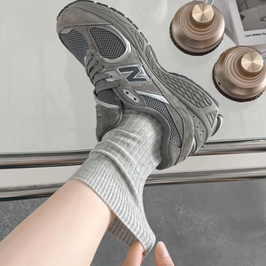 Details von hellgrauen gerippten Socken kombiniert mit grauen Wildleder-Sneakern