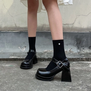 Detail of black patent leather platform Mary Janes with chunky heels and heart socks