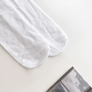 Detailed macro view of white Lolita lace socks with reinforced toe stitching and soft knit texture