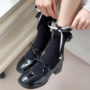 Détail de chaussettes en dentelle noire et rubans avec des chaussures Mary Jane vernies