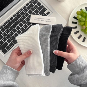 Nahaufnahme von vier Paar gerippten Baumwollsocken in Weiß, Grau und Schwarz