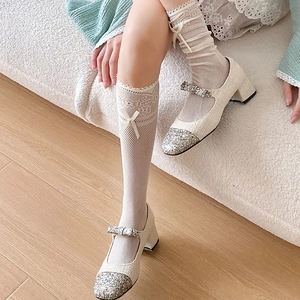 Close-up of Lolita lace mesh socks with bow detail and cream sequin Mary Jane shoes