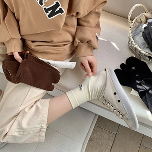 Detail of split-toe flip-flop socks in beige and brown cotton knit with embroidery