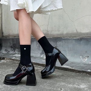 Detail of black Mary Jane heels with chunky soles and white heart patterned socks