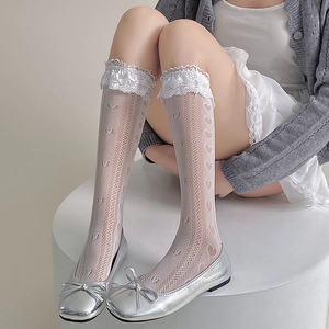 Détail de chaussettes à bordure en dentelle avec motifs cœur et chaussures argentées