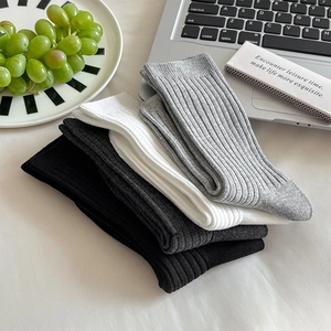 Detail von gerippten Strick-Socken in Schwarz, Grau und Weiß mit Baumwollstruktur