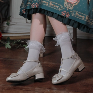 Détail de chaussures Mary Jane crème avec nœud, perles et chaussettes en dentelle blanche