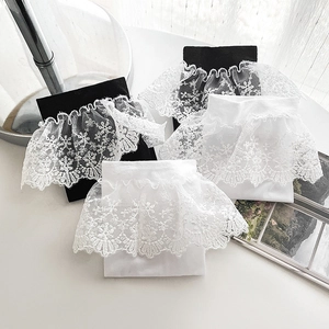 Detailed view of Lolita style lace ruffled socks in black and white with embroidery