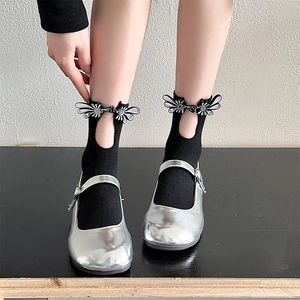 Detail of silver Mary Jane shoes with vintage buckle and black butterfly wing socks
