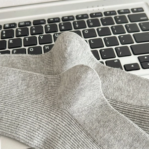 Detail von grauen Rippstrick-Socken mit verstärkter Ferse und hochwertiger Baumwollstruktur