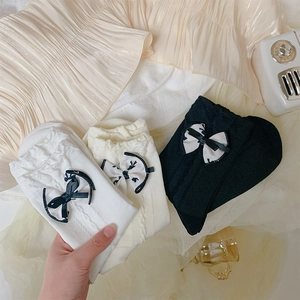 Close-up of Japanese-style knit socks with lace cuffs and elegant bow details
