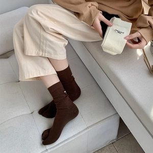 Close-up of split-toe socks in coffee and beige with embroidered stylish lettering