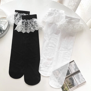 Detail of Lolita style mid-calf socks with white floral lace trim in black and white