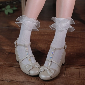Détail de chaussettes en maille blanche à volants et chaussures Mary Jane avec perles