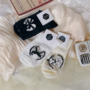 Detailed knit texture of three pairs of bow-knot socks in black white and beige colors