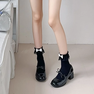 Détail de chaussettes résille Lolita avec dentelle et nœuds et souliers Mary Jane