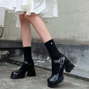 Detail view of black patent leather platform Mary Janes with chunky heels and heart socks
