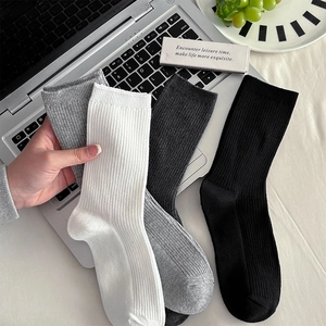 Details von gerippten Socken in Weiß, Grau und Schwarz mit elastischem Bündchen