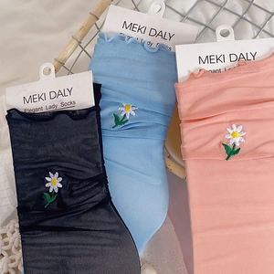 Detail of daisy embroidery and ruffled lace cuffs on sheer mesh lady socks in three colors