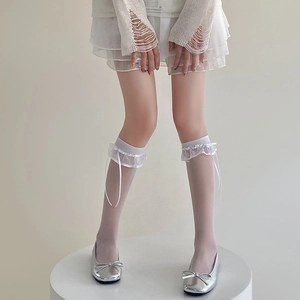 Détail de chaussettes hautes blanches avec volants en organza et rubans délicats