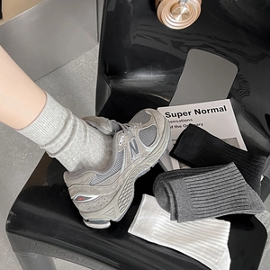 Detail von gerippten Baumwollsocken in Grau Schwarz und Weiß in neutralen Farben