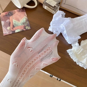 Détail de chaussettes blanches en dentelle avec motif cœur et haute élasticité
