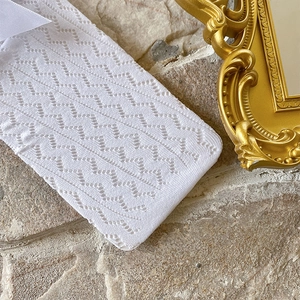 Close-up of white pointelle knit socks featuring delicate zigzag mesh and soft texture