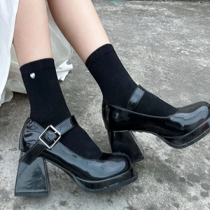 Close-up of black patent leather platform Mary Janes with silver buckle and chunky heel