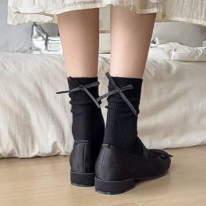 Ribbed knee-high socks with back bow tie detail paired with satin ballet flats
