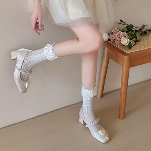Détail de chaussettes en dentelle blanche avec chaussures Mary Jane à perles et roses