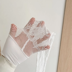 Vue détaillée du tissu en dentelle blanche évidée avec motifs floraux et élasticité