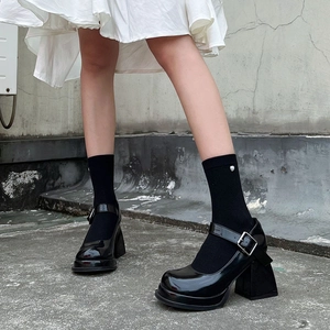 Close-up of black patent leather Mary Jane shoes with thick platform and square heels