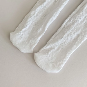 Détail du motif en maille ajourée blanche sur les chaussettes hautes pour la respirabilité