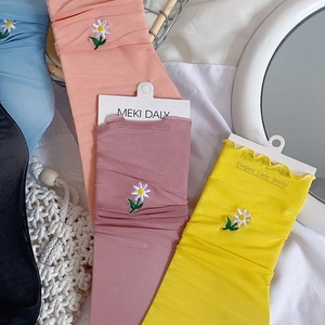 Close-up of daisy embroidery on sheer mesh socks in multiple pastel colors