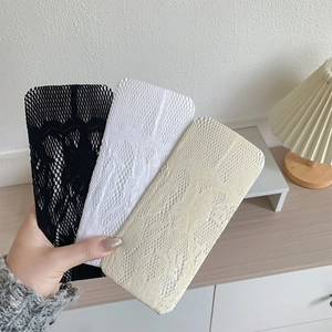 Détail du motif en dentelle florale sur des chaussettes hautes en maille respirante tricolores