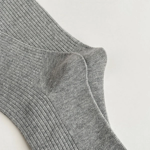 Detail of grey ribbed knit texture and reinforced heel stitching on ballet socks