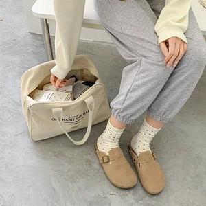 Polka-Dot-Socken kombiniert mit Wildleder-Mules und einer Segeltuchtasche