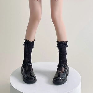 Détail de chaussettes noires à bordure en dentelle avec chaussures Mary Jane à plateforme