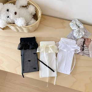 Detailed view of lace trim and ribbon bows on sheer calf-high socks in three colors