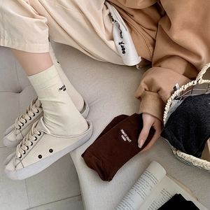 Detail of knit Tabi socks with march must made embroidery and split-toe canvas sneakers