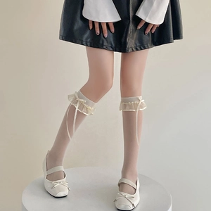 Détail de chaussettes hautes Lolita blanches avec volants en dentelle et nœuds en soie