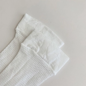 Detail showing the breathable white mesh knit texture and wide smooth cuff of these socks